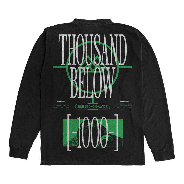 A black Thousand Below ShakaWear long-sleeve shirt features bold white THOUSAND BELOW text and green graphics. BURIED-IN-JADE and [1000] appear on the back. Made from heavy garments with presale shipping available.