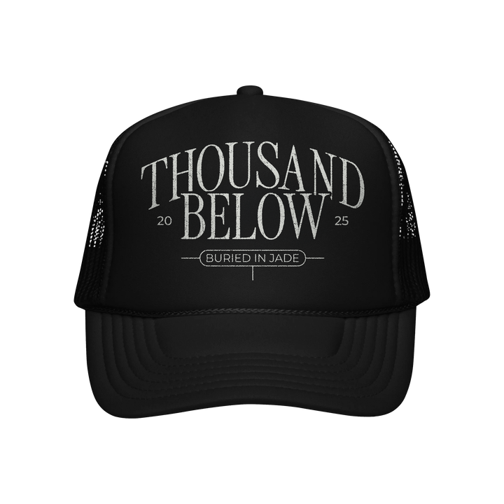 A premium black Decky mesh trucker hat by Thousand Below featuring THOUSAND BELOW 2025 in bold and BURIED IN JADE in smaller text on the front. Available now for presale.