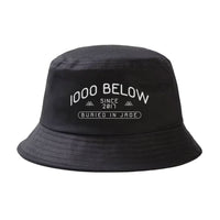 A Thousand Below bucket hat made from durable twill, featuring white text "1000 BELOW SINCE 2017 BURIED IN JADE" and two small mountain icons above the date.