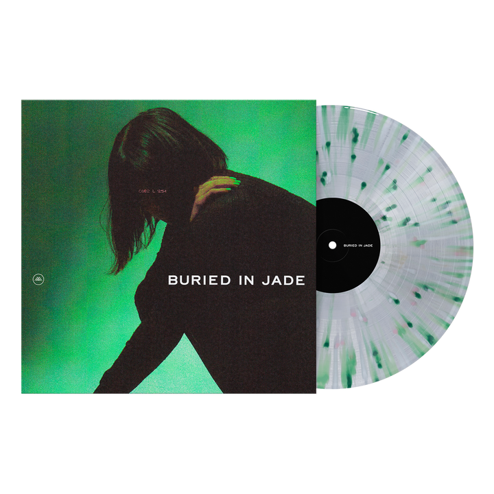 A black and green splatter vinyl LP by Thousand Below rests partly in its cover, featuring a dark-haired figure on a green background with bold BURIED IN JADE text—an essential for any Kerosene collection.