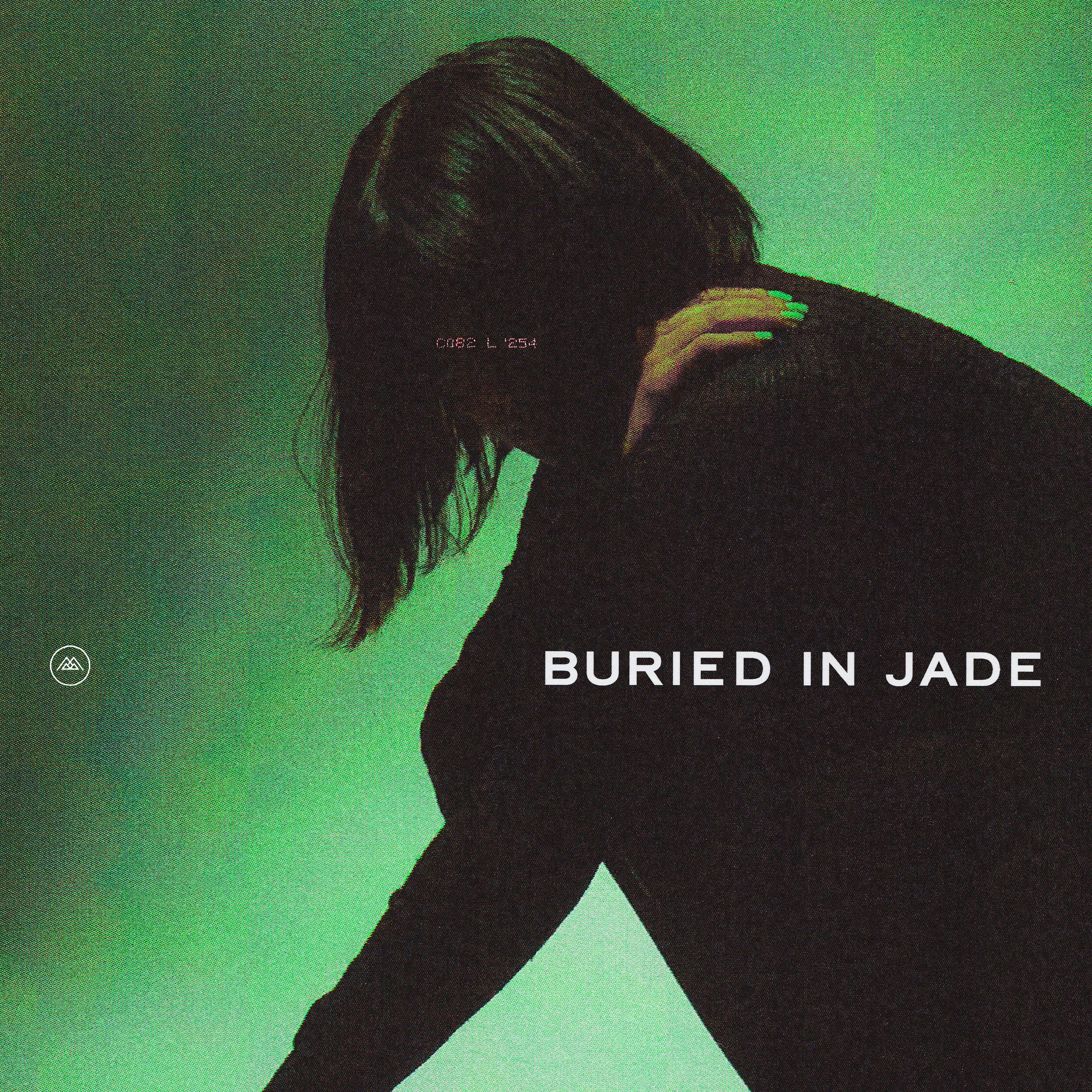 A person with shoulder-length hair leans forward against a green background, their face hidden. Their nails are painted green. White text reads BURIED IN JADE. The overall image has a moody, atmospheric tone.
