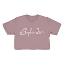 A mauve cropped t-shirt from Saphir Levi, featuring their name printed in white decorative script across the front—ideal for fans of stylish garments.