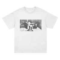 SIIICKBRAIN white T-shirt with a black-and-white print of a person sitting beside a cow in a stall, centered on the front. Printed on soft Comfort Colors fabric. Ships 4/3/26.