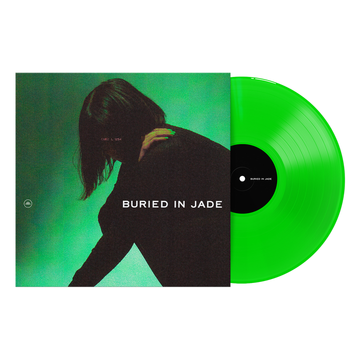 A Neon Green Vinyl LP by Thousand Below rests next to its album cover, featuring a shadowy figure on green with BURIED IN JADE in bold white letters. Available now for presale.