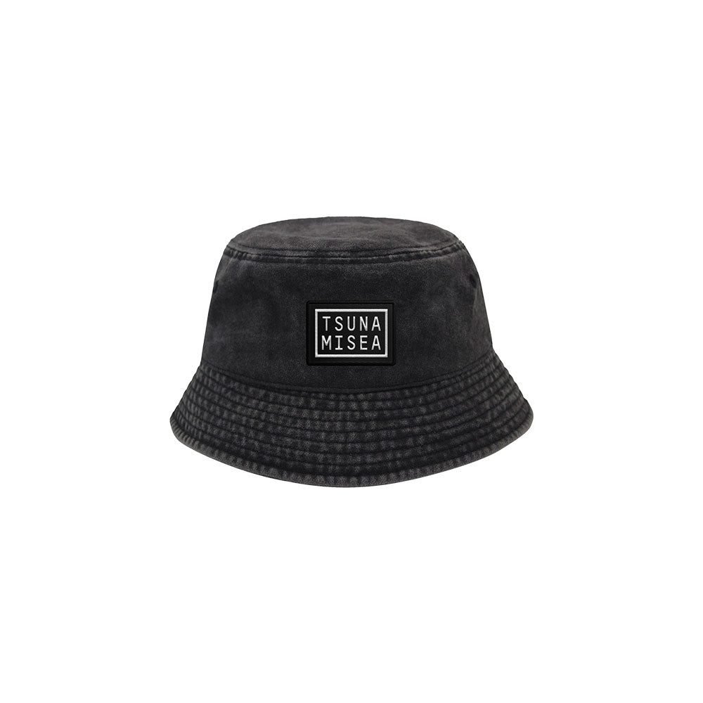 A Spiritbox Pigment Black Bucket Hat with a wide brim and a front rectangular patch featuring TSUNA MISEA in bold white letters, displayed on a plain white background.