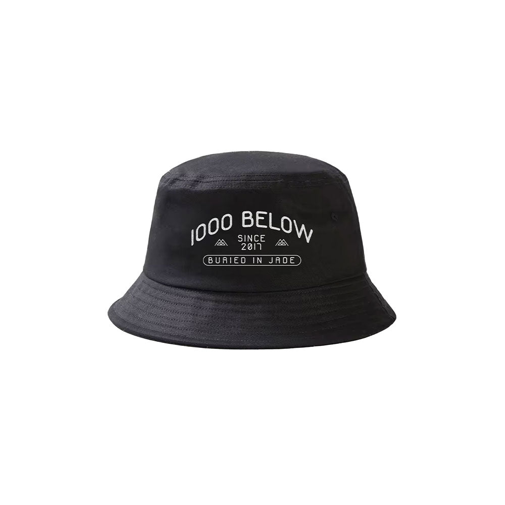 A black Thousand Below bucket hat with white "1000 BELOW SINCE 2011" text above a rectangle labeled "BURIED IN JADE.