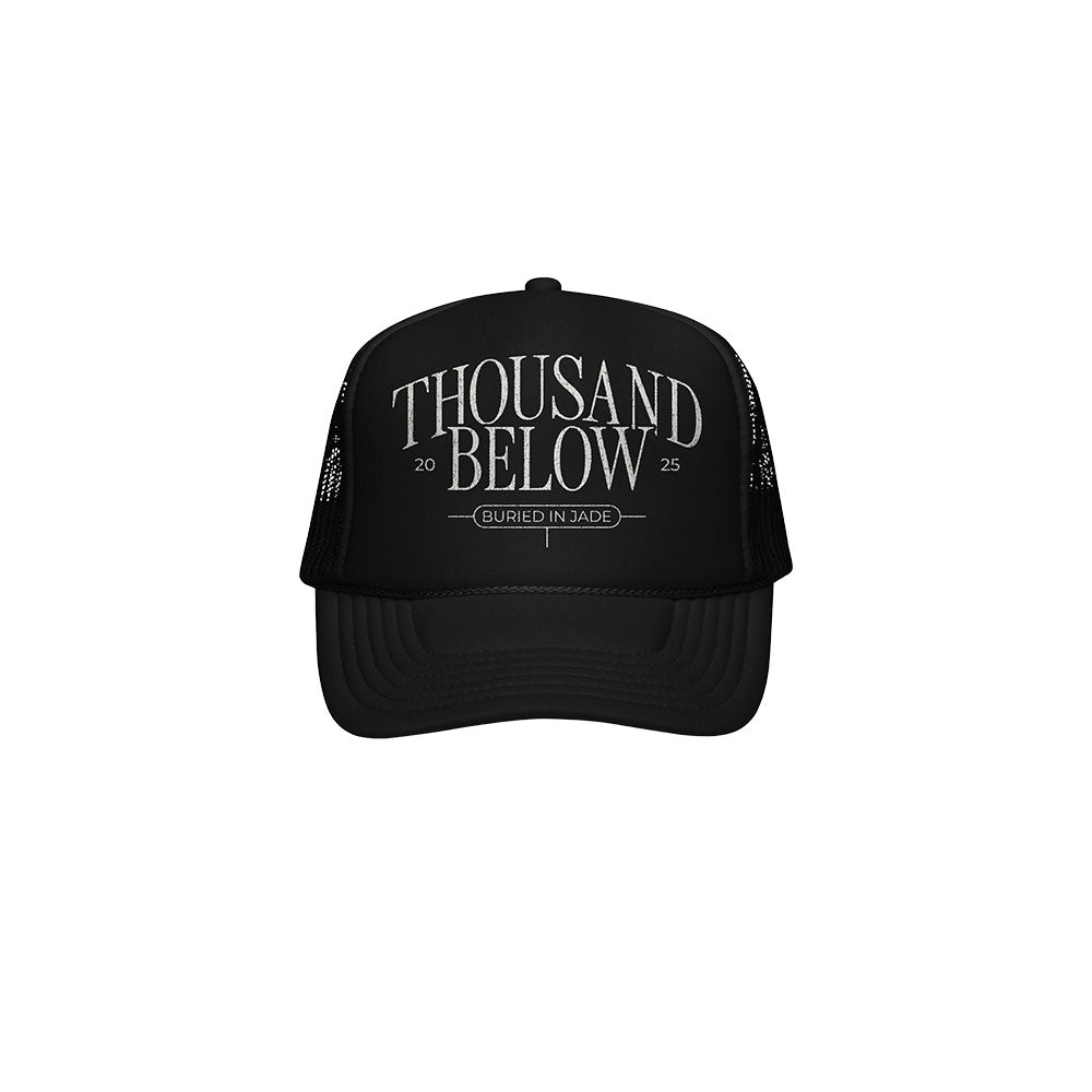 A black mesh trucker hat by Thousand Below features “THOUSAND BELOW” in large white letters and “20 25 BURIED IN JADE” below—a must-have accessory for fans.