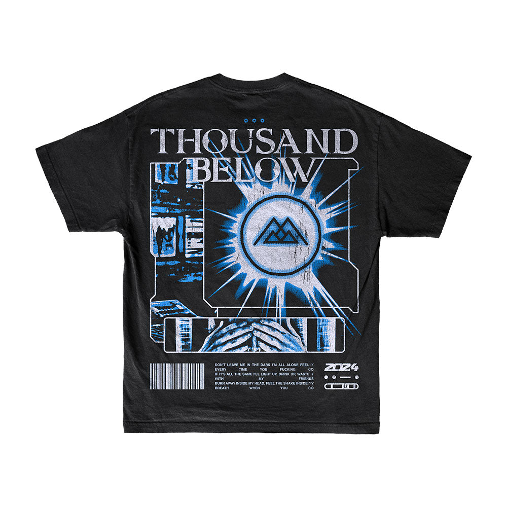 Thousand Below Black Shake T-Shirt with a futuristic blue and white design features the band name on top, a circular emblem, abstract digital patterns, small text block, and barcode below.
