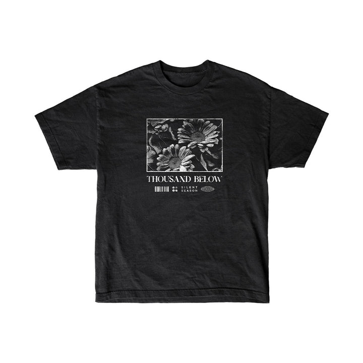 Black T-shirt by Thousand Below with a square grayscale flower graphic, "Thousand Below" and "Silent Season" text, and subtle barcode-inspired details below the design.