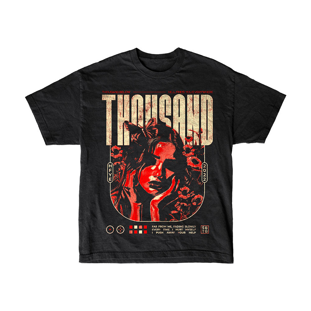 Thousand Below Black Sabotage T-Shirt features a red and beige graphic of a woman's face with flowers, bold logo text above, and vintage poster-style details below, inspired by classic band merch.