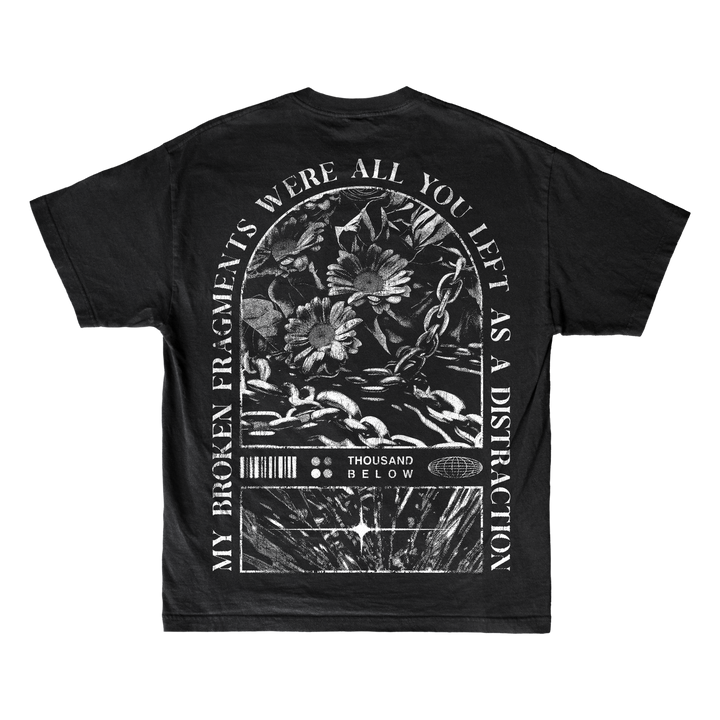 A black Thousand Below Gildan Softstyle T-Shirt with a gothic white graphic of flowers, chains, and text on the back. Made from ring-spun cotton for a modern classic fit and lasting comfort.
