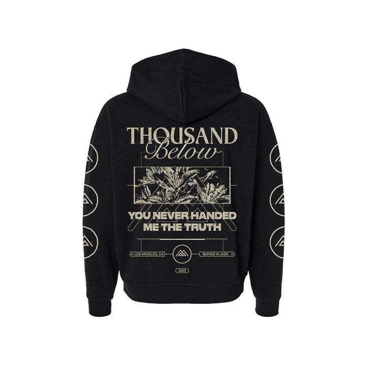 Black hoodie by Thousand Below featuring the band's name on the back above a leaf image, with "YOU NEVER HANDED ME THE TRUTH" below. Circular symbols appear along the sleeves.