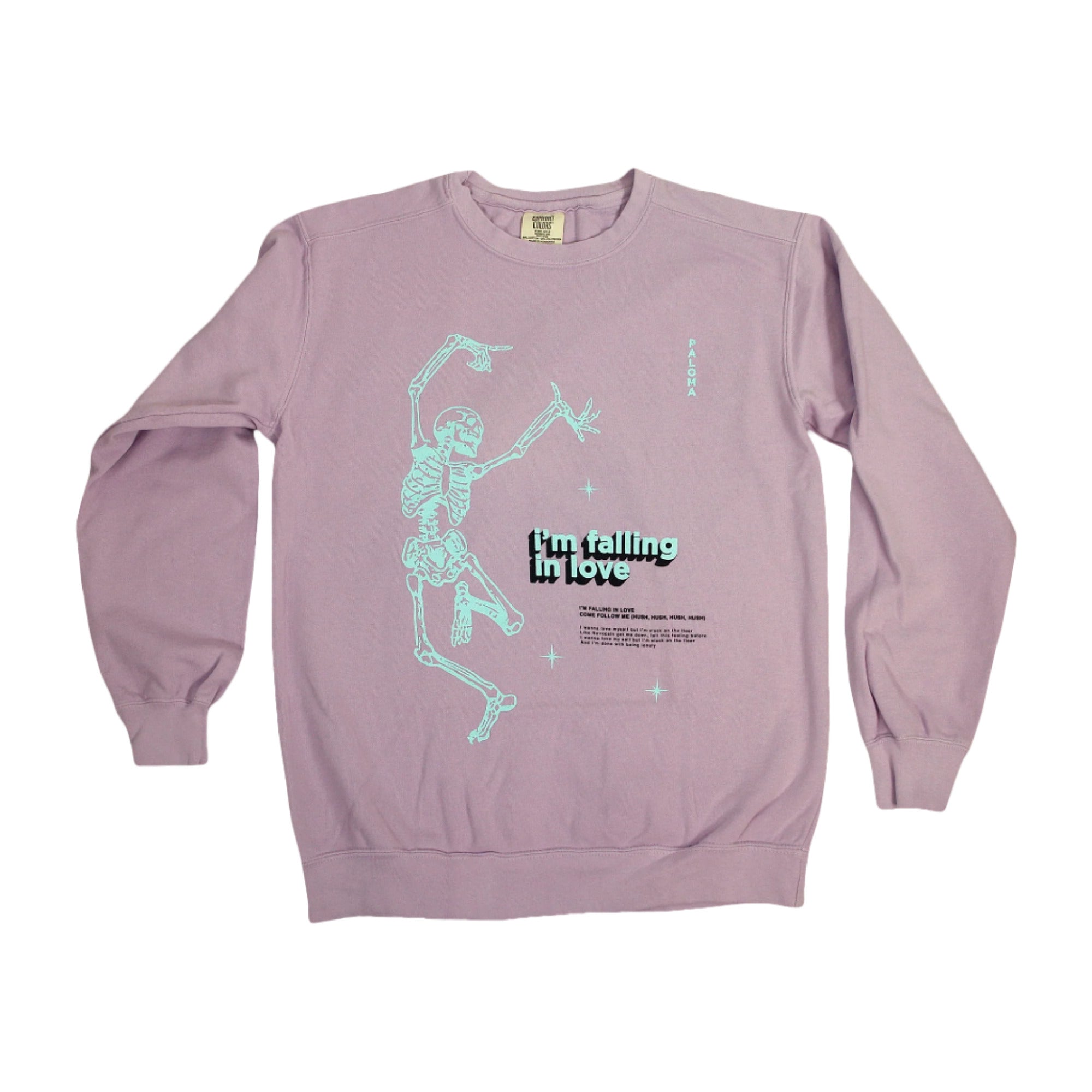 The Paloma lavender Comfort Colors crewneck sweatshirt features a light blue dancing skeleton graphic and "I'm falling in love" text on the front, offering a relaxed fit for everyday comfort.